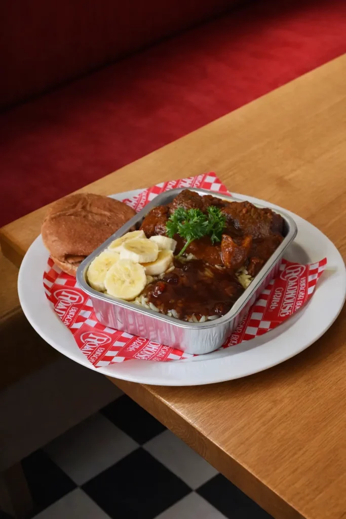 Plated Burger Box hot meal served with bread and lemon slices on a wooden table