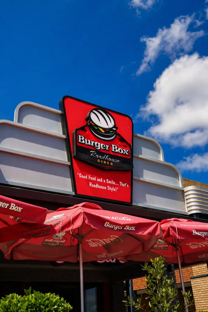 Exterior Burger Box Roadhouse sign against a blue sky outside the restaurant